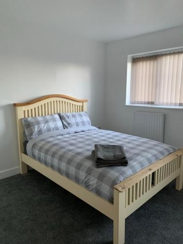a bed with a wooden frame in a bedroom at Campion Contractor Stays With Parking in Sheffield