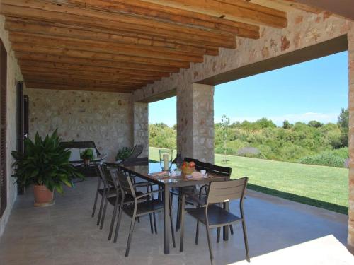 a dining room with a table and chairs on a patio at Elegant Villa with Private Pool in Porto Cristo
