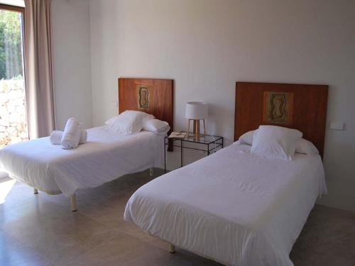 two beds in a room with a window at Elegant Villa with Private Pool in Porto Cristo