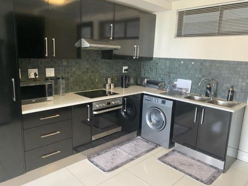 a kitchen with a sink and a washing machine at Tranquility Luxury Suite, 77 on Independence Ave in Windhoek