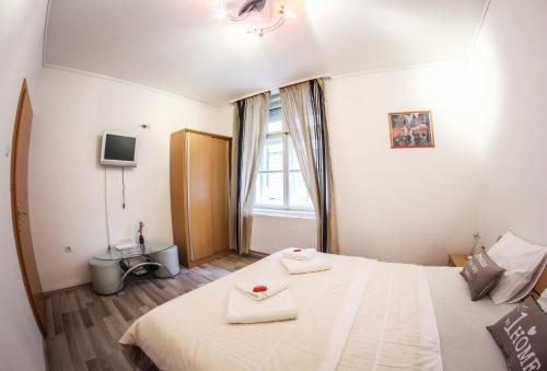 Un dormitorio con una gran cama blanca y una ventana en Rooms Eliza, en Zagreb