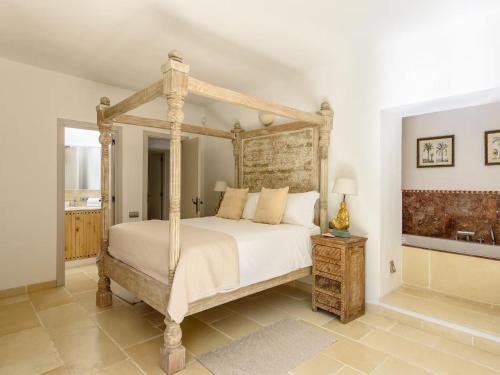 a bedroom with a bed with a wooden frame at Farmhouse in Ibiza with Bali Pavilion in Santa Gertrudis de Fruitera
