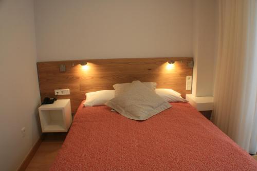 a bedroom with a large red bed with two night stands at Hotel Picos De Europa in Santander