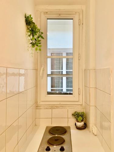 une cuisine avec une cuisinière et une fenêtre dans l'établissement Paris Center Quarter Latin Nice 1 bedroom, à Paris