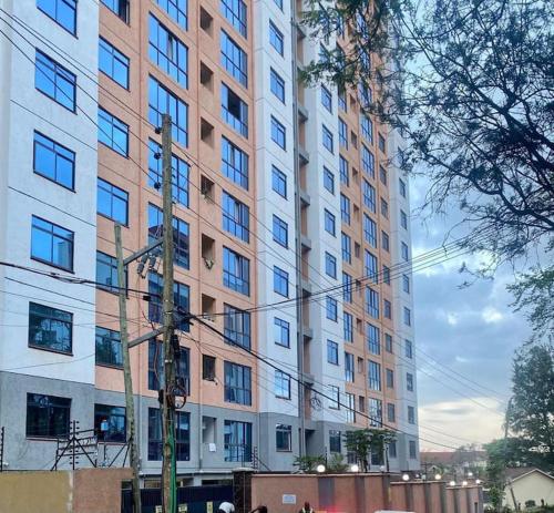 a large tall building with many windows on a street at Delight Studio, Kaisa Gardens Kileleshwa in Nairobi