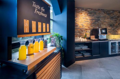 a counter with a bunch of bottles of orange juice at Diamond Capsule Hotel Amsterdam South in Amstelveen