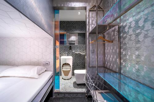a small bathroom with a bed and a shower at Diamond Capsule Hotel Amsterdam South in Amstelveen