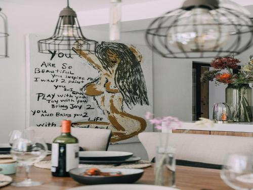 a dining room table with a painting of a woman at Holiday Home in Ibiza near Las Salinas Beach in Cala Vadella