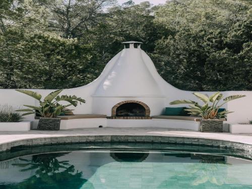 a swimming pool in front of a white building with a fireplace at Holiday Home in Ibiza near Las Salinas Beach in Cala Vadella