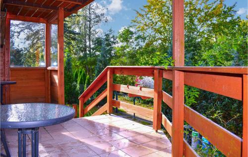 una veranda in legno con tavolo e recinzione di Nice Home In Brodnica Górna With Sauna a Brodnica Dolna