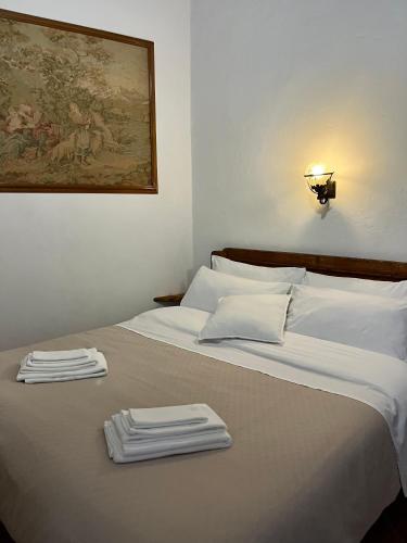 a bed with white sheets and towels on it at Il Girasole Storico in Pitigliano