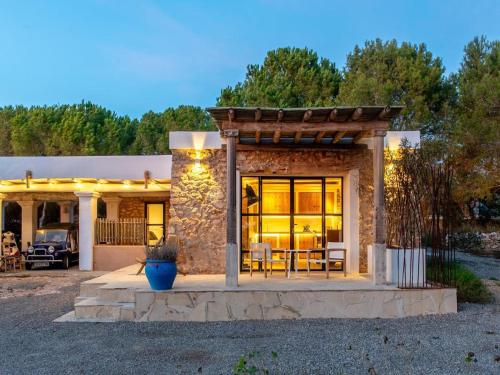 a stone house with a patio with a table at Farmhouse in Ibiza with Saltwater Pool in Puig D’en Valls