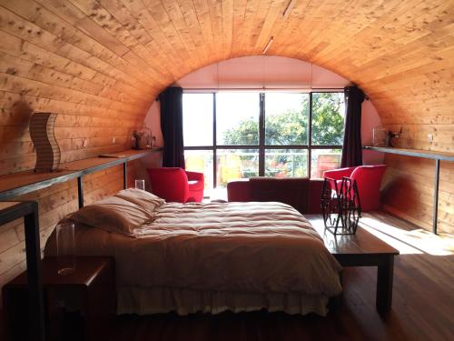 a bedroom with a bed and a large window at Finca El Tambor Nature Reserve, Lodging and Tours in Antigua Guatemala