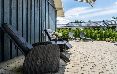a patio with chairs and a table and a fence at Beautiful Home In Strøby With Wifi in Strøby