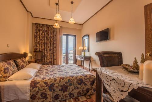 a bedroom with a bed and a table and a window at Marianna's Home Accommodation in Karpenision