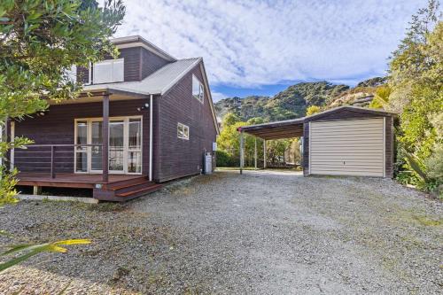 a home with a garage and a house at Aroha at Tata - Golden Bay Holiday Home in Takaka