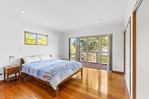 a white bedroom with a bed and a window at Aroha at Tata - Golden Bay Holiday Home in Takaka