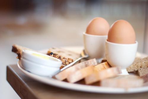 a plate of eggs and cheese and bread on a table at ibis Europe Chalon Sur Saone in Chalon-sur-Saône
