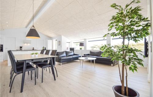 una sala da pranzo e un soggiorno con tavolo e sedie di Holiday Home Lakolk Rømø Denmark a Bolilmark