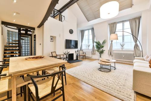 a living room with a table and chairs and a couch at Light and Airy Central London Apartment in London