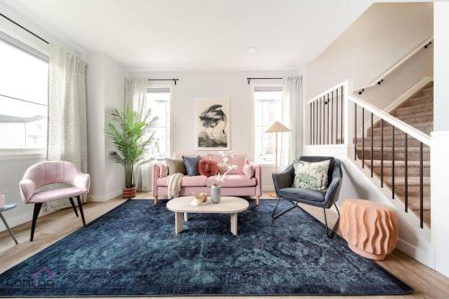 a living room with a pink couch and two chairs at The Nest, 3BR, AC, Near YEG Airport, King Bed! in Edmonton