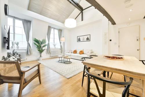a living room with a table and a couch at Light and Airy Central London Apartment in London