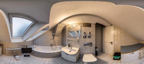 a large bathroom with a tub and a sink and a bath tub at Ferienwohnungen Leipzig Musikviertel Zentrum Süd - zentral und dennoch ruhig in Leipzig
