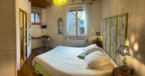 a bedroom with a bed and a window at Les Petits Gallais in Saint-Carreuc