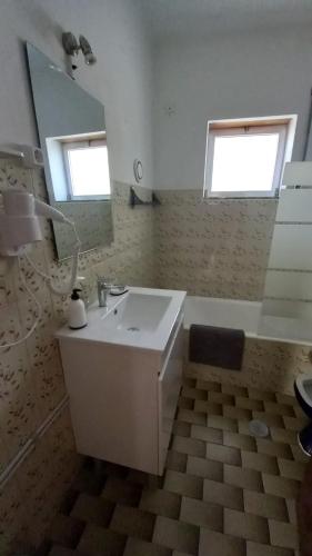 a bathroom with a white sink and a mirror at Casa do Tonito in Carregal do Sal