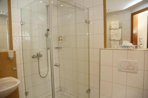 a shower with a glass door in a bathroom at Hotel Lindleinsmühle in Würzburg