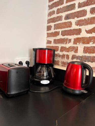 two appliances sitting on a counter with a brick wall at La Terrasse Urbaine Epinal in Épinal