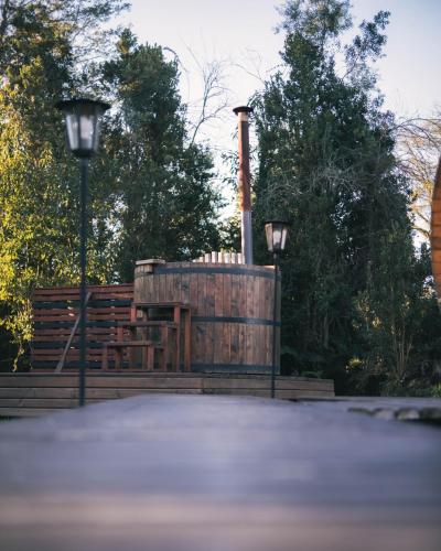 a wooden barrel with a chimney and two street lights at Entre Volcanes Lodge in Ensenada