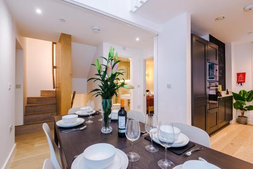a dining room with a table and white chairs at King Street Collection in Manchester