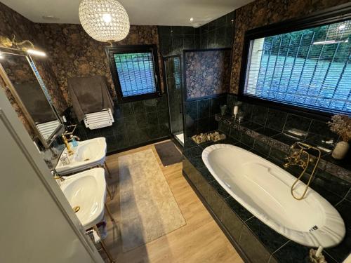 a bathroom with two sinks and a bath tub at Villa vue panoramique, 6 chambres, piscine chauffée in Espalion