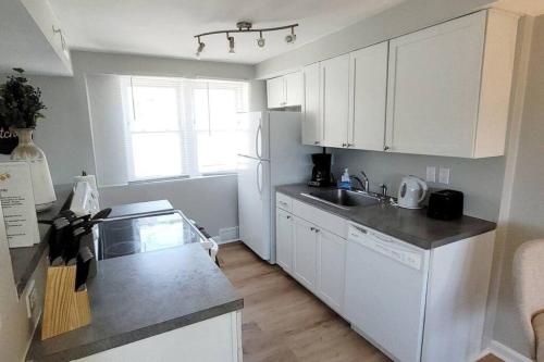 a kitchen with white cabinets and a white refrigerator at Davenport Dwellings-Walk to UNMC in Omaha
