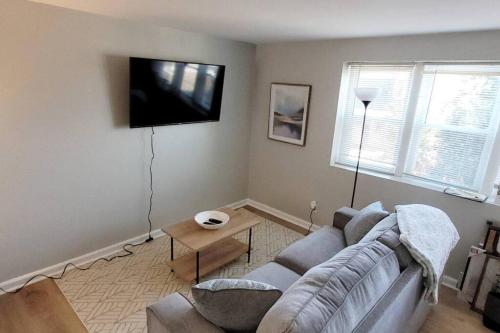 a living room with a couch and a flat screen tv at Davenport Dwellings-Walk to UNMC in Omaha