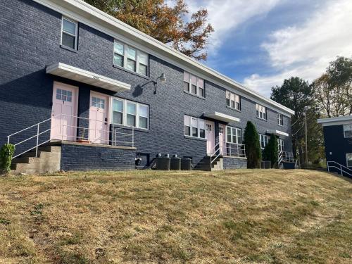 a gray house with pink doors and a yard at Davenport Dwellings-Walk to UNMC in Omaha