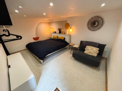 une chambre avec un lit et un canapé dans l'établissement La Dépendance d'Obernai - Parking Gratuit - Centre Ville - Commerces à proximité, à Obernai