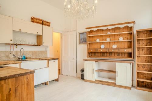 a kitchen with white cabinets and a chandelier at Palace View Apartment in Buxton