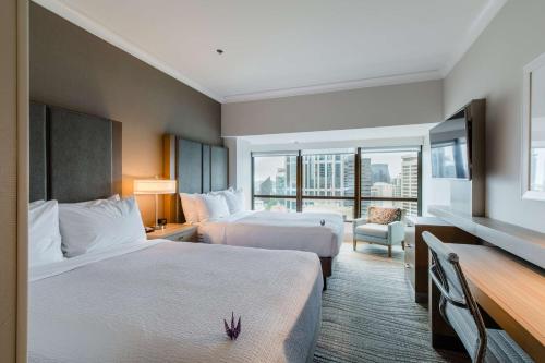a hotel room with two beds and a balcony at Coast Seattle Downtown Hotel by APA in Seattle