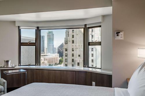 a bedroom with a large window with a city view at Coast Seattle Downtown Hotel by APA in Seattle