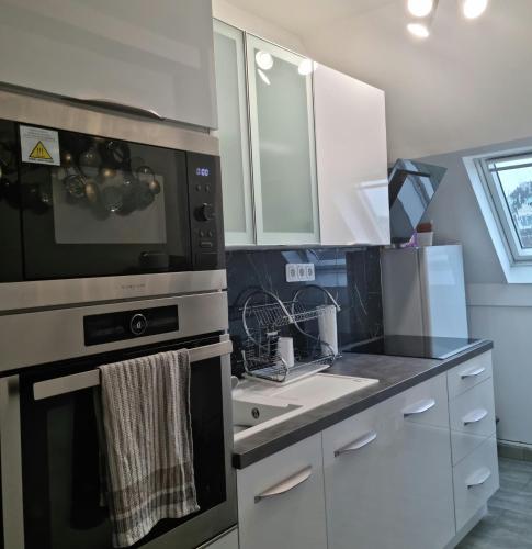 une cuisine avec un évier et une cuisinière four supérieur dans l'établissement magnifiqueT3 hyper centre beauvais design confort, à Beauvais