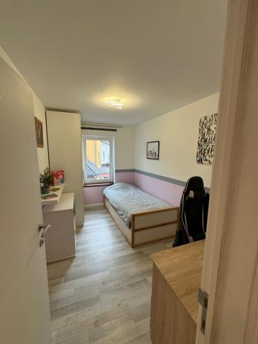 a small bedroom with a bed and a window at hébergement pour 3 personnes, 2 chambres in Overijse