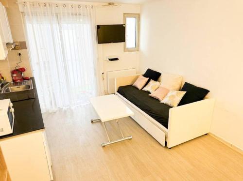 un salon avec un canapé et une table dans l'établissement Appartement front de mer, à Canet