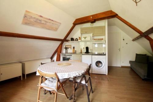 une cuisine et une salle à manger avec une table dans une pièce dans l'établissement Bel appartement T2 cabine, à Loudenvielle