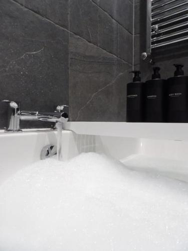a bathroom sink with water coming out of it at Modern 3BHK near Edinburgh zoo in Edinburgh