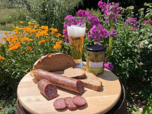 a wooden table with bread and a glass of beer at Der Bauerngarten in Hofgeismar