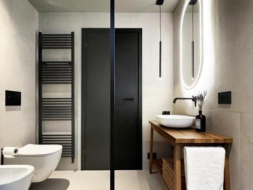 a bathroom with two sinks and a toilet at Dimora 1895 in Teglio