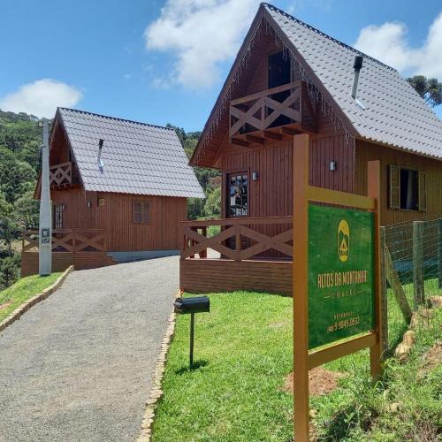 a large wooden building with a sign in front of it at Chalés Altos Da Montanha - Mont Blanc in Bom Jardim da Serra