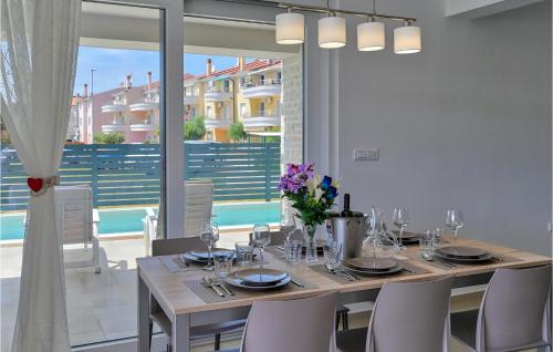 a dining room with a table and chairs and a large window at Villa Medulin 1 in Medulin